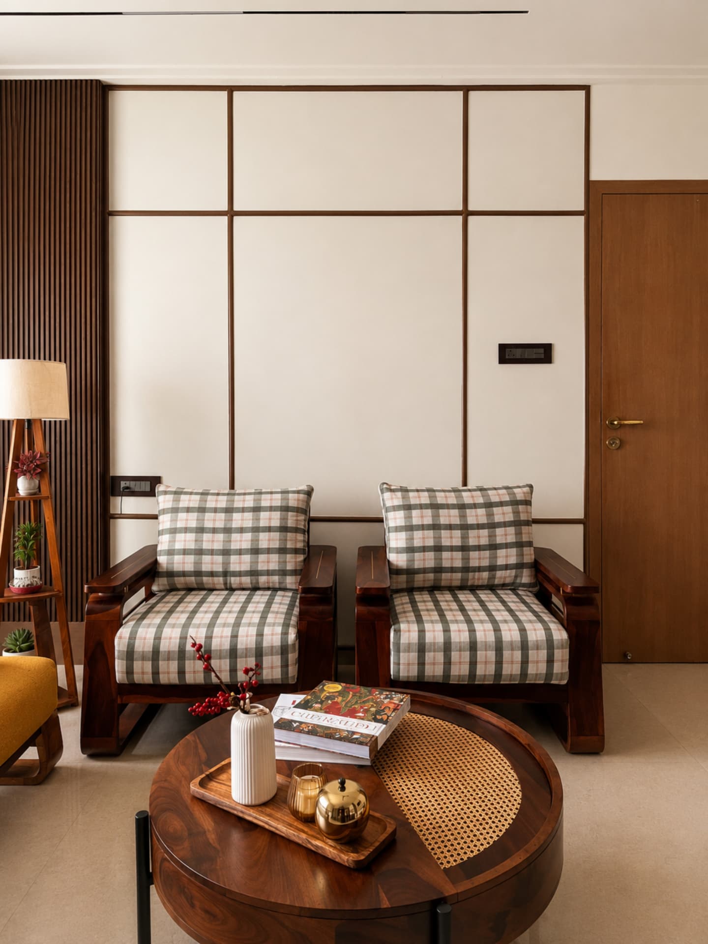 Pair of sheesham armchairs in checked linen against a framed panelled wall
