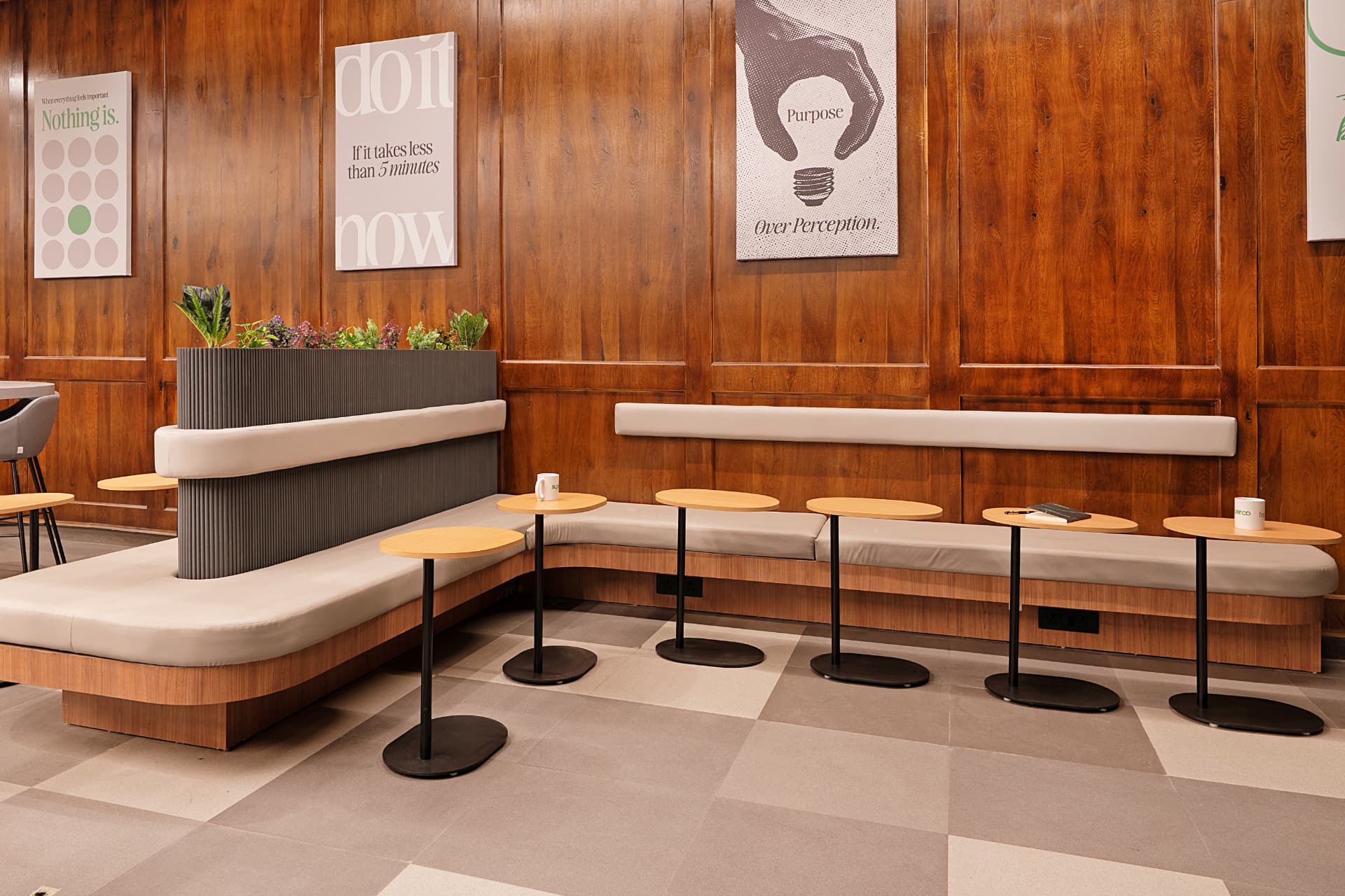 Leather banquette seating with perch tables and a planted divider