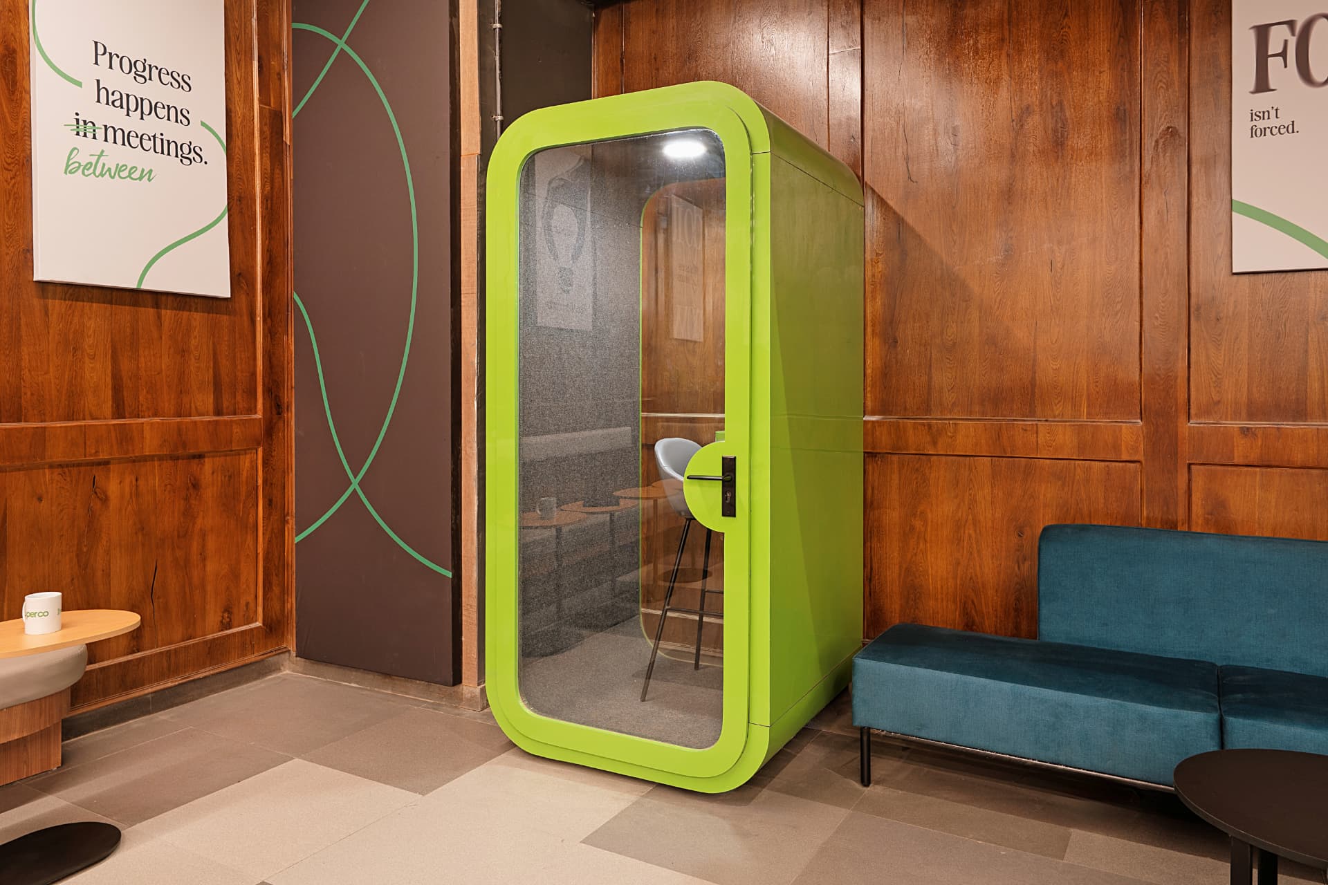Lime green acoustic focus pod set into a teak panelled wall